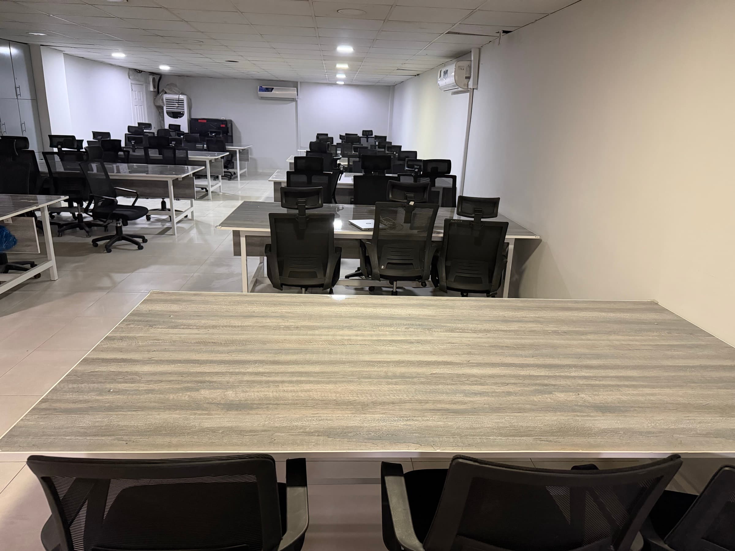 Desks arranged in rows across the shared floor, with more workstations along the far wall.